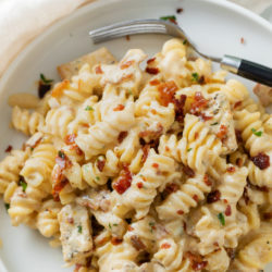 A labeled image of Chicken Bacon Spinach Pasta with a fork on a white plate.