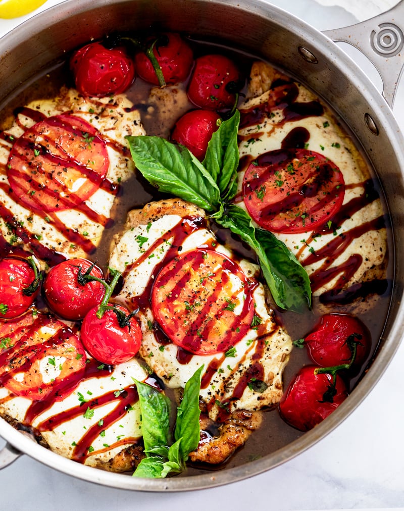 Caprese Chicken in a Skillet with Balsamic Sauce, Tomatoes, Basil, and Balsamic Glaze.