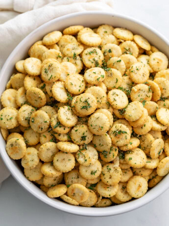 A white bowl filled with Ranch Oyster Crackers with seasonings.