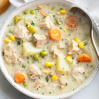 Creamy Chicken Soup in a white soup bowl with a spoon on the right side.