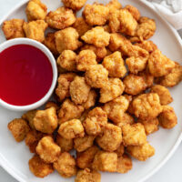 Popcorn Chicken on a white plate with Sweet and Sour Sauce.