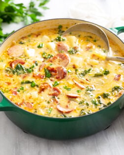 Side view of Kielbasa Potato Soup in a soup pot with a ladle in the back.