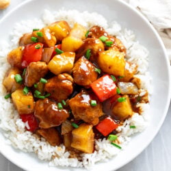 A white bowl filled with Pineapple Chicken over white rice.