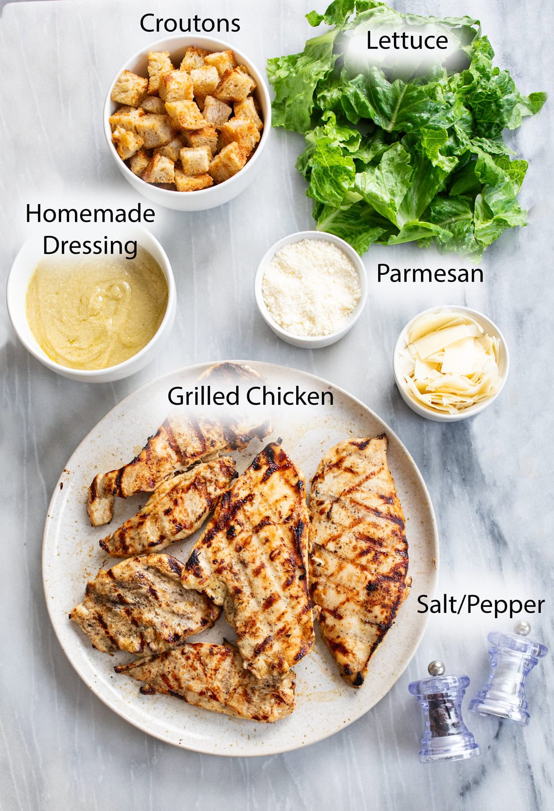 Overhead view of ingredients needed to make homemade Chicken Caesar Salad.